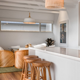 Leila Rattan Bar Stool styled at a kitchen island, showcasing its natural finish and airy silhouette.